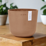 Oslo Eco Pot in Terracotta on timber table with green plants in background