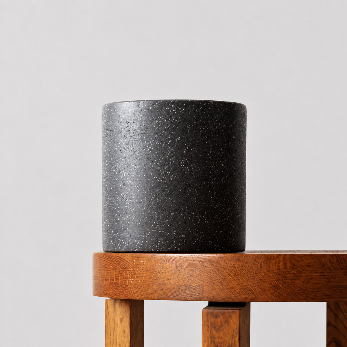 Jardin black terrazzo pot on a timber table against a soft grey background.