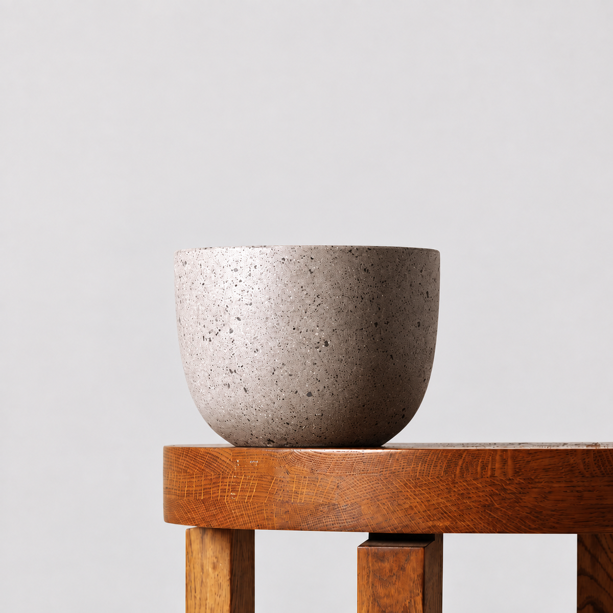 Pierre grey terrazzo pot on a timber table against a soft grey background.