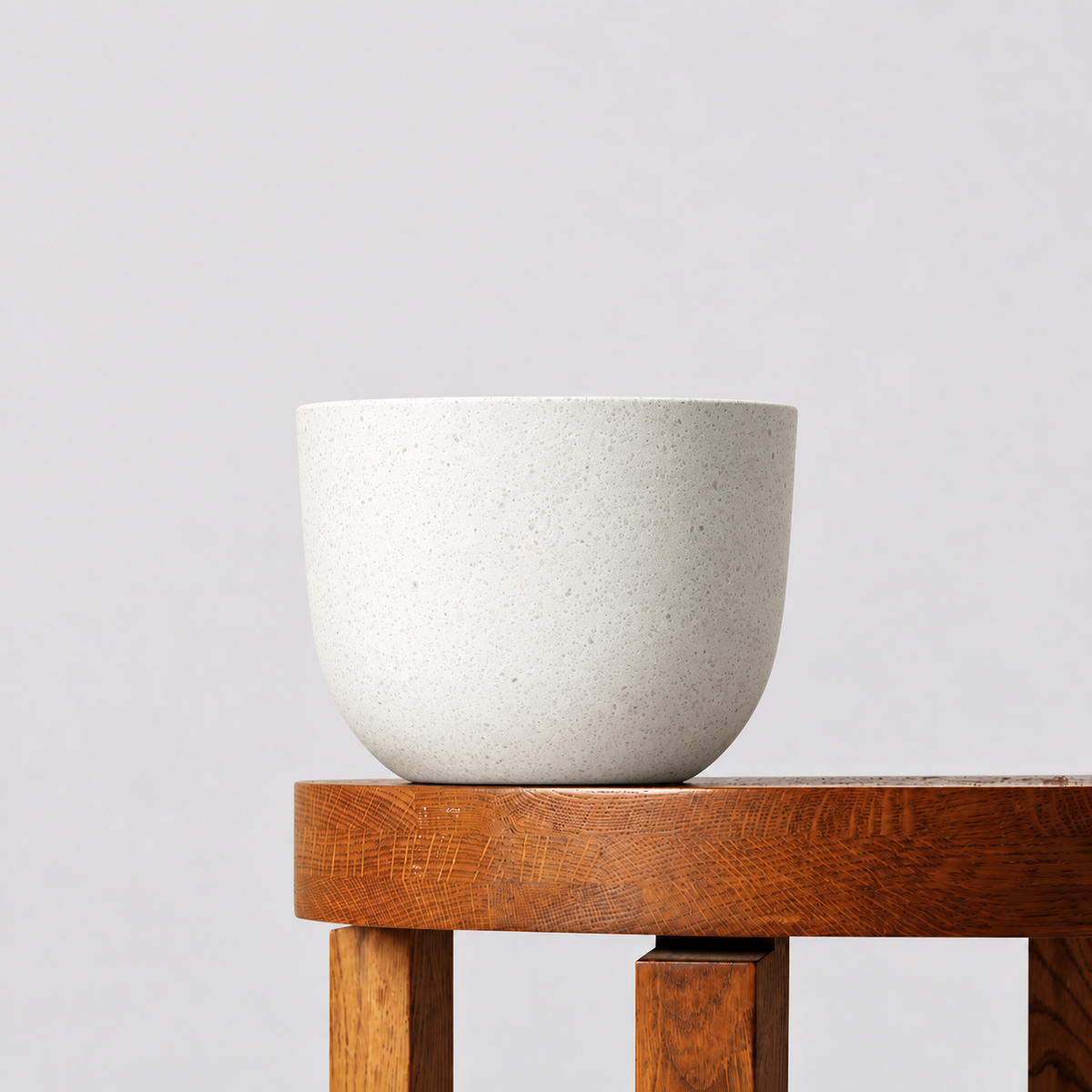 Pierre white terrazzo pot on a timber table against a soft grey background.