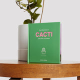 Little Book of Cacti with a green cover on a table.